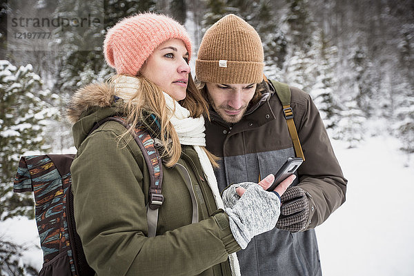 Paar auf Winterreise mit dem Handy
