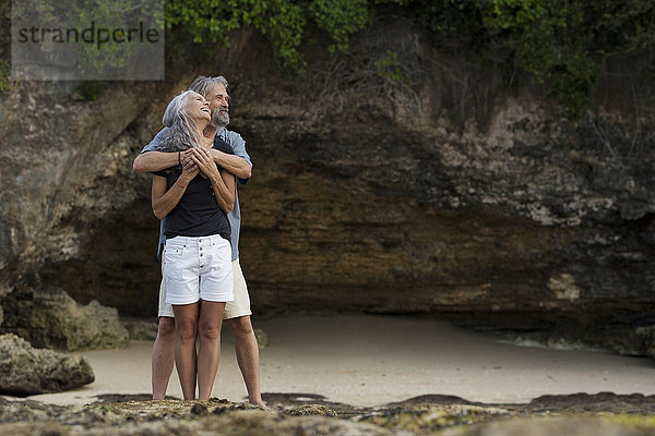 Liebevolles Seniorenpaar beim Umarmen am Strand