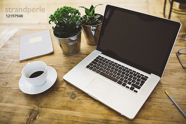 Laptop und eine Tasse Kaffee auf einem Tisch