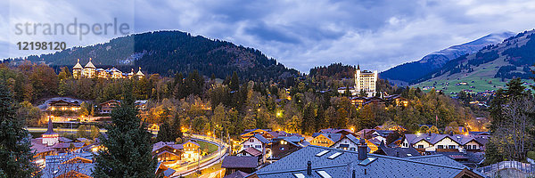 Schweiz  Kanton Bern  Gstaad  Stadtbild mit Gstaad Palace Hotel in der Abenddämmerung