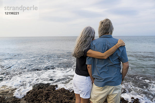 Seniorenpaar mit Blick auf den Ozean  Rückansicht