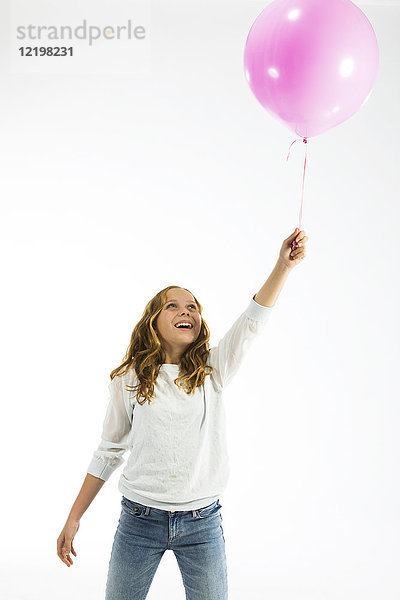 Mädchen spielt mit rosa Ballon