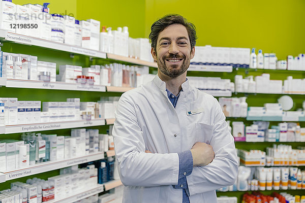Porträt eines lächelnden Apothekers im Regal mit Medizin in der Apotheke