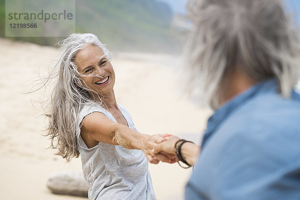 Hübsches Seniorenpaar tanzt am Strand