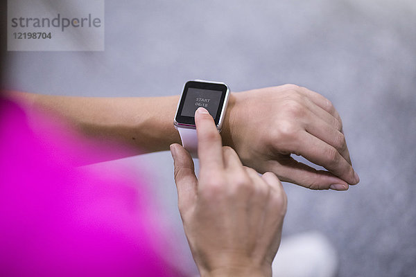 Nahaufnahme der weiblichen Hände bei der Kontrolle von smartwatch