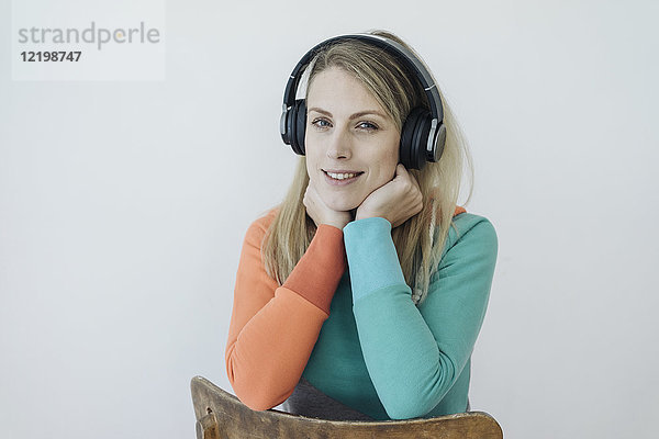 Porträt einer lächelnden Frau mit kabellosen Kopfhörern