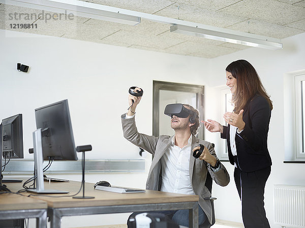 Frau mit Mann mit VR-Brille im Büro