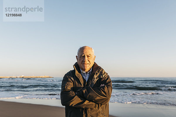 Ein älterer Mann  der am Strand spazieren geht.