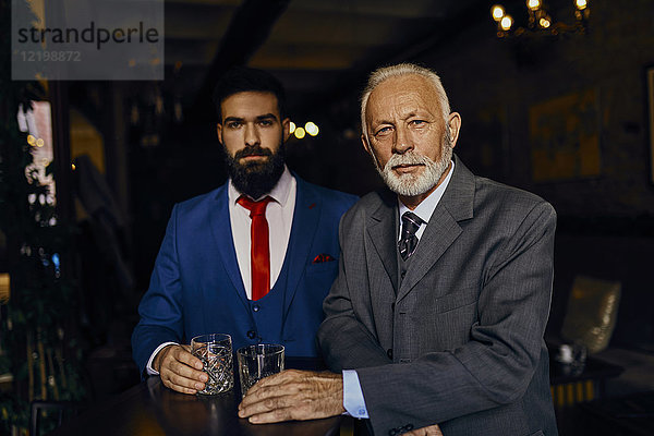 Porträt von zwei eleganten Männern in einer Bar mit Bechern