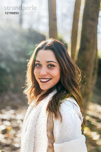 Porträt einer schönen lächelnden Frau im Herbstwald