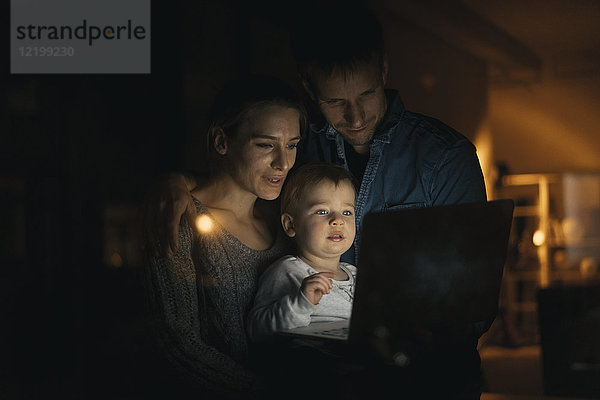 Familie mit Laptop im Dunkeln