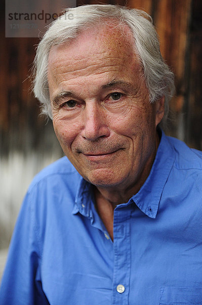 Porträt eines lächelnden älteren Mannes im blauen Hemd