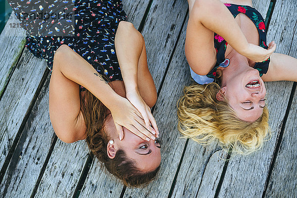 Panama  Bocas del Toro  Zwei lachende Frauen auf dem Holzsteg liegend