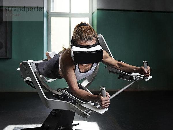 Frau mit VR-Brille mit futuristischem Fitnessgerät