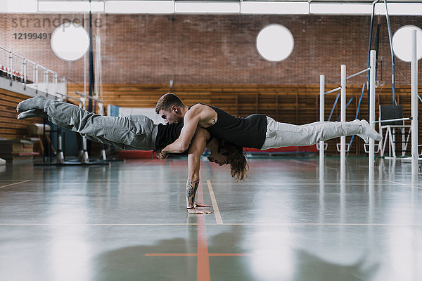 Zwei Männer bei der Akrobatik im Fitnessstudio