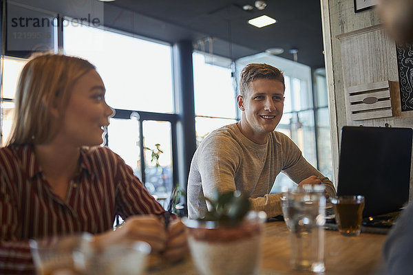 Lächelnde Freunde treffen sich in einem Cafe