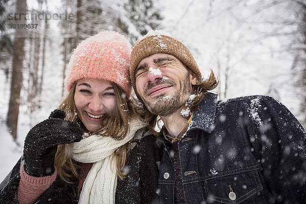 Glückliches Paar beim Schneevergnügen in der Winterlandschaft