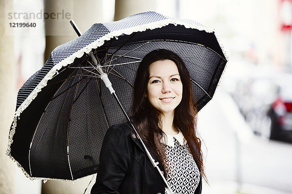 Porträt der modischen jungen Frau mit schwarzem Vintage-Schirm