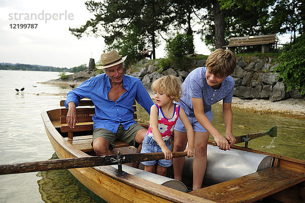 Deutschland  Bayern  Murnau  Großvater mit Enkel und Enkelin im Ruderboot