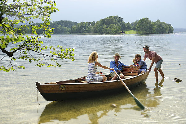 Deutschland  Bayern  Murnau  Familie im Ruderboot am Seeufer