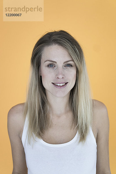Porträt einer lächelnden Frau vor gelbem Hintergrund