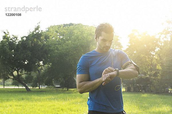 Läufer im Stadtpark überprüft seine Smartwatch