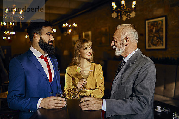 Zwei elegante Männer und Frauen  die sich in einer Bar treffen.