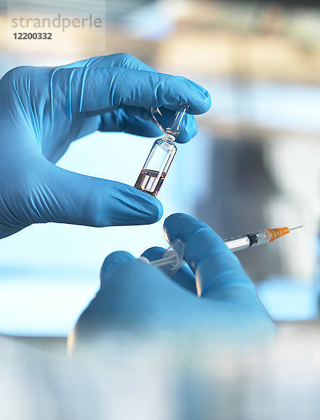 Wissenschaftler hält ein Fläschchen mit einer Flüssigkeit im Labor