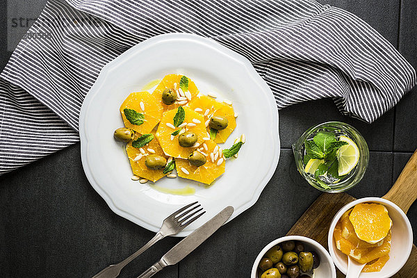 Salat mit Orangenscheiben  Pinienkernen  grünen Oliven und Minzeblättern