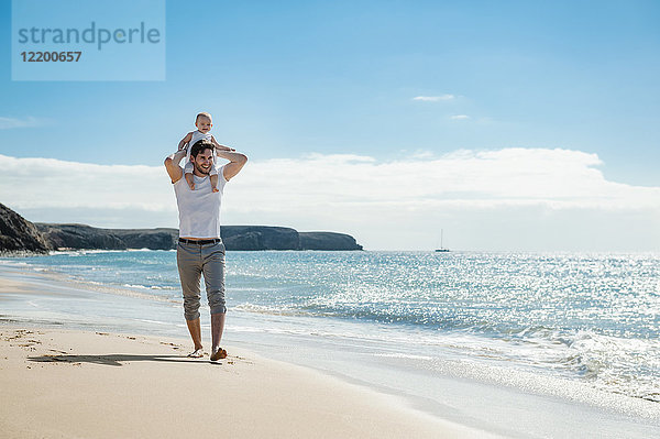 Spanien  Lanzarote  Vater mit kleiner Tochter auf den Schultern am Strand