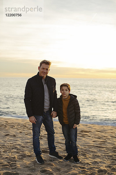 Porträt von Vater und Sohn am Strand stehend
