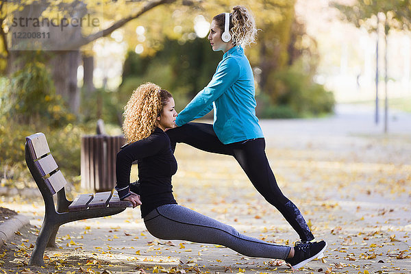 Zwei sportliche junge Frauen beim Stretching im Park