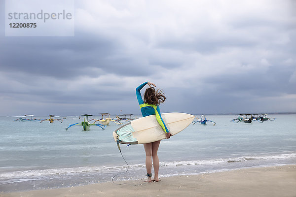 Indonesien  Bali  junge Frau mit Surfbrett