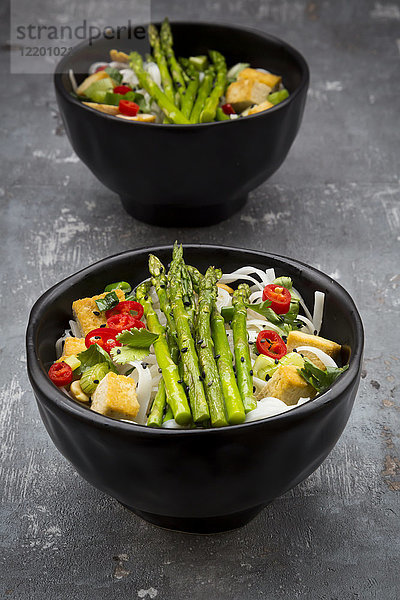 Schale mit veganem Pad Thai mit mini grünem Spargel und Tofu  Chili  Frühlingszwiebel  Erdnuss und Koriander