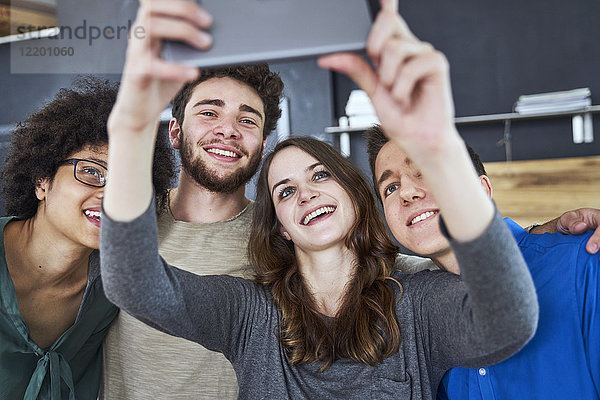Lächelnde Mitarbeiter  die einen Selfie im Büro nehmen