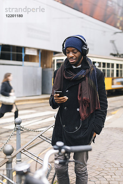 Afroamerikaner mit Smartphone und Kopfhörer