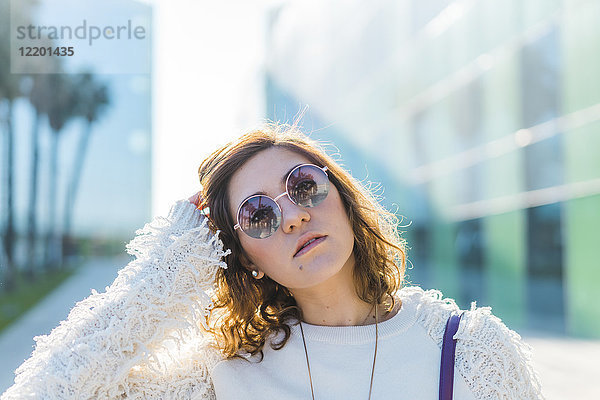 Porträt einer jungen Frau mit Sonnenbrille im Freien