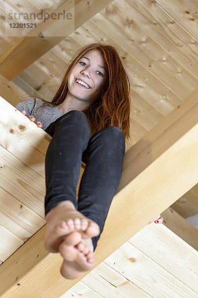 Porträt eines lachenden rothaarigen Mädchens auf dem Dachboden