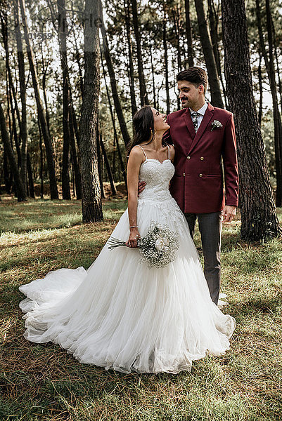 Glückliche Braut und Bräutigam im Wald stehend