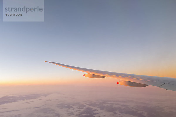 Europa  Flugzeugflügel mit Wolken bei Sonnenaufgang