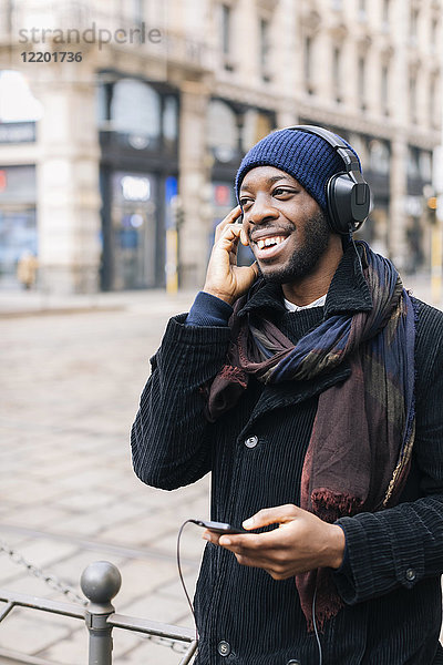 Afroamerikaner mit Smartphone und Kopfhörer