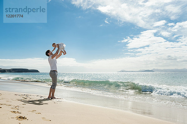 Spanien  Lanzarote  Vater mit seiner kleinen Tochter am Strand