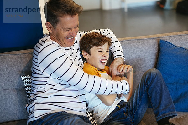 Sorgenfreier Vater und Sohn haben Spaß auf der Couch zu Hause