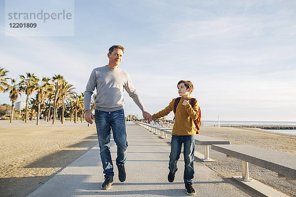 Vater und Sohn beim Spaziergang an der Strandpromenade