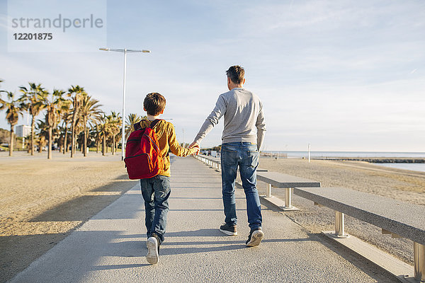 Vater und Sohn beim Spaziergang an der Strandpromenade