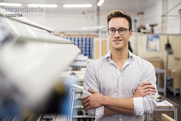 Porträt eines lächelnden jungen Geschäftsmannes in der Fabrik