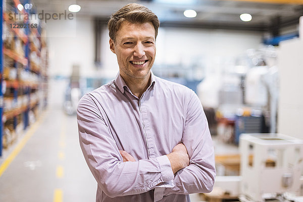 Porträt des lächelnden Geschäftsmannes in der Fabrik