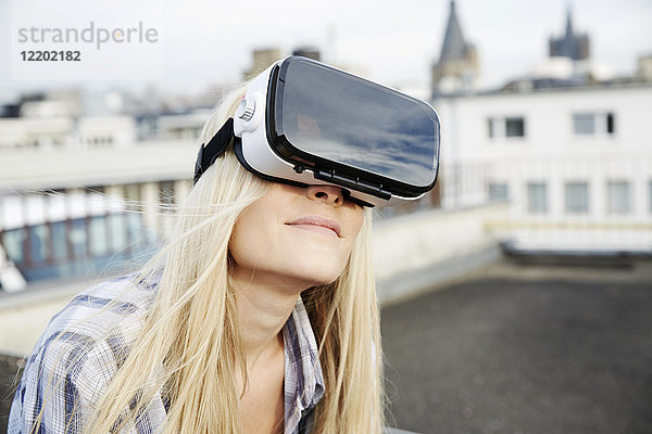 Porträt einer Frau mit Virtual Reality Brille im Freien