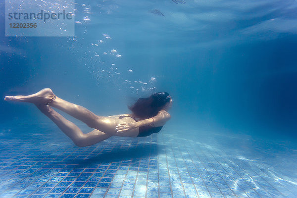 Junge Frau unter Wasser im Schwimmbad