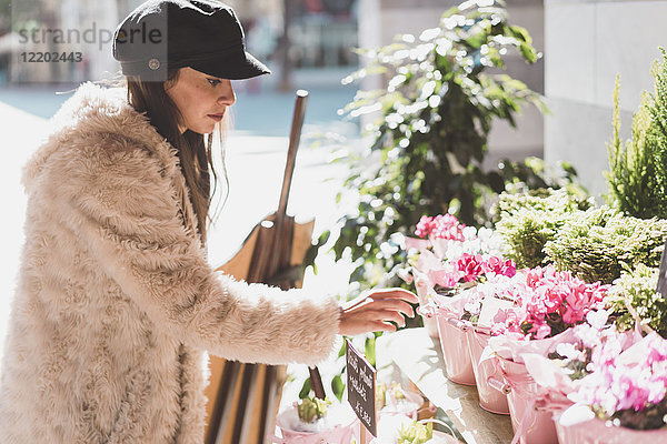 Stilvolle junge Frau beim Blumenkauf in der Stadt